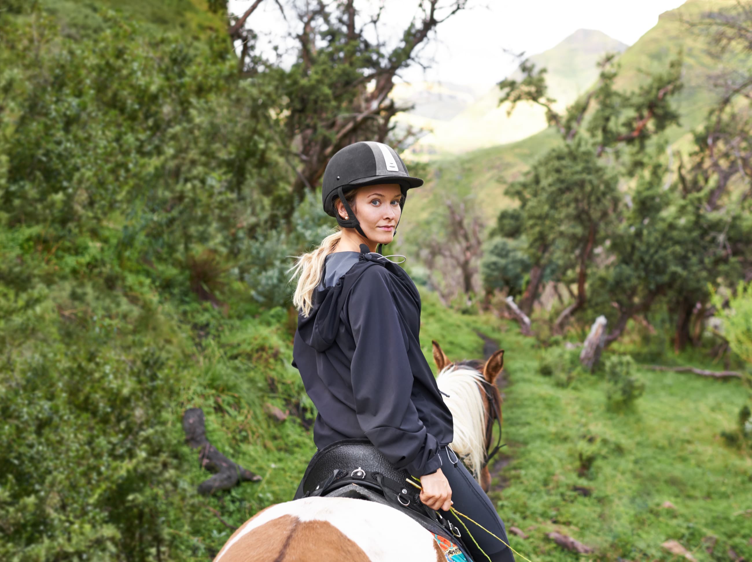 Horseback rider moving across open terrain