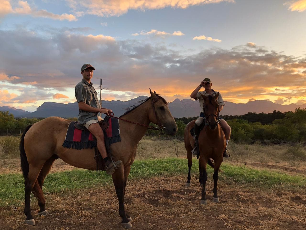 Two mounted riders under a painted sky