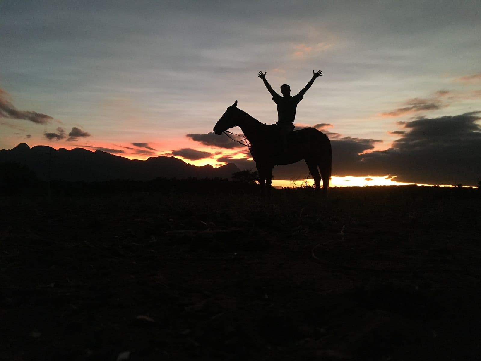 Riders celebrating beneath the sunset